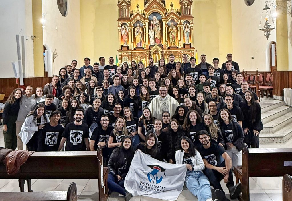 Jovens reunidos em oração no encontro do Ministério Universidades Renovadas, com momentos de adoração e comunhão fraterna