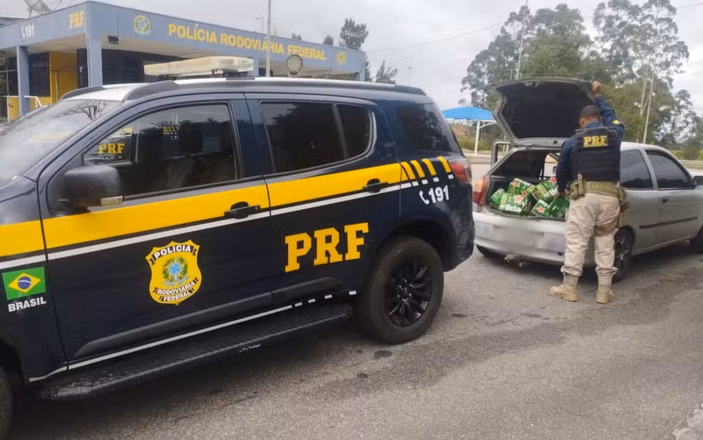 Policiais rodoviários federais fiscalizam veículo com parte da carga de cerveja após saque na rodovia Fernão Dias