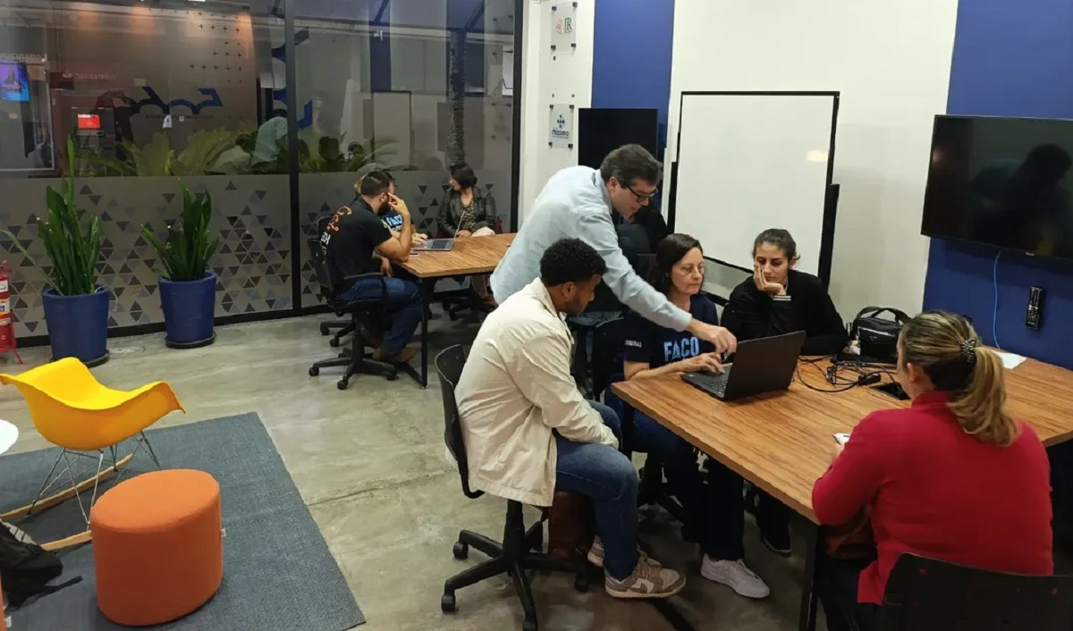 Imagem de estudantes de contabilidade auxiliando um cliente no balcão do Núcleo de Apoio Contábil e Fiscal (NAF) do Unilavras, com foco em Imposto Territorial Rural (ITR).