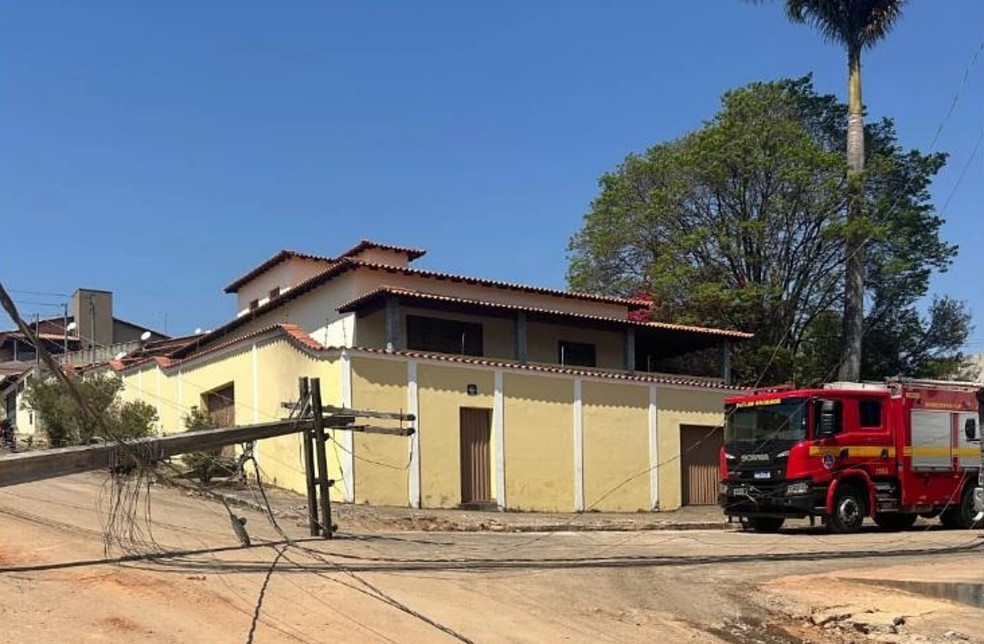 Imagem mostra bombeiros em Lavras isolando área após queda de poste de energia sobre carro