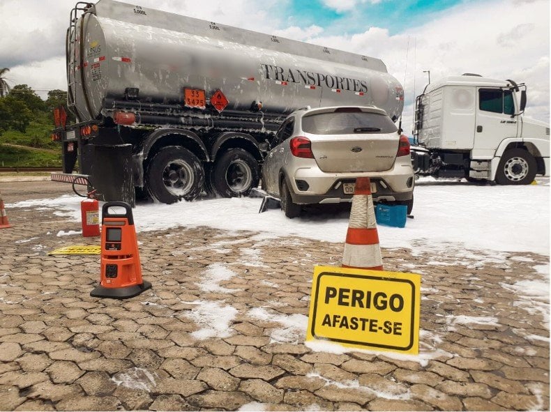 Caminhão-tanque e viaturas em Simulado de Acidente com Carga Perigosa em Lavras na BR-381, com foco em contenção de óleo diesel e treinamento de equipes
