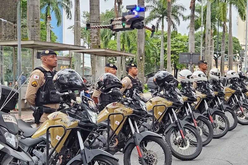 Policiais militares da PMMG em Minas Gerais equipados com motocicletas oficiais e drone de monitoramento durante a Operação Cavalo de Aço contra rolezinhos.