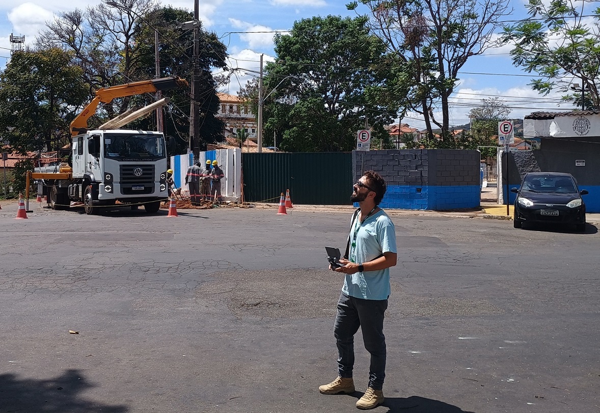 Drone profissional da Cemig realizando inspeção térmica em torre de alta tensão em área rural de Minas Gerais