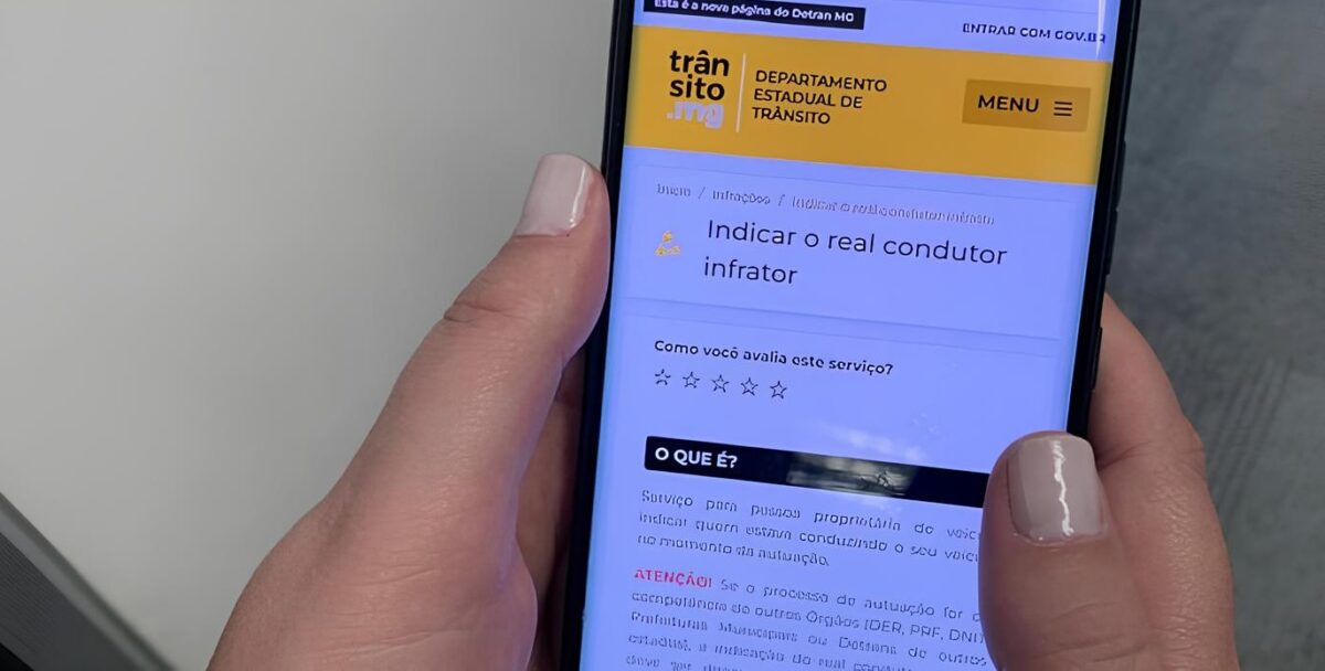 Mulher acessando o portal do Detran para realizar a indicação de condutor infrator em um celular